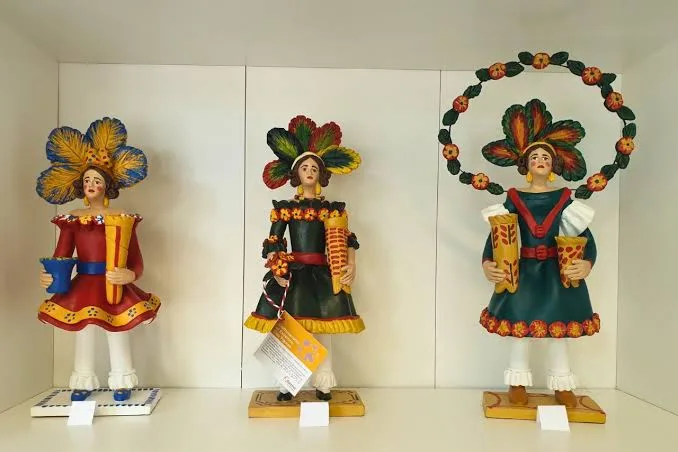 Three clay Estremoz figures in colourful traditional dress on display