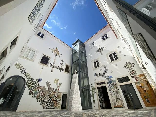 Courtyard of the Tile Museum in Estremoz, with a glass lift and tile patterns on the walls