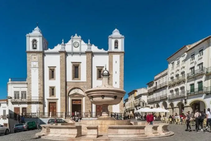 Praça do Giraldo in Évora, with a marble fountain and a white church with two towers
