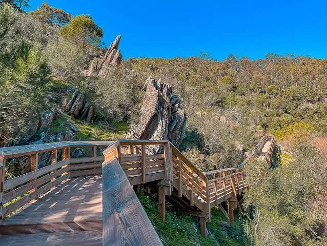 Wooden walkway and steps through a rocky hillside on the Passadiços da Serra d'Ossa