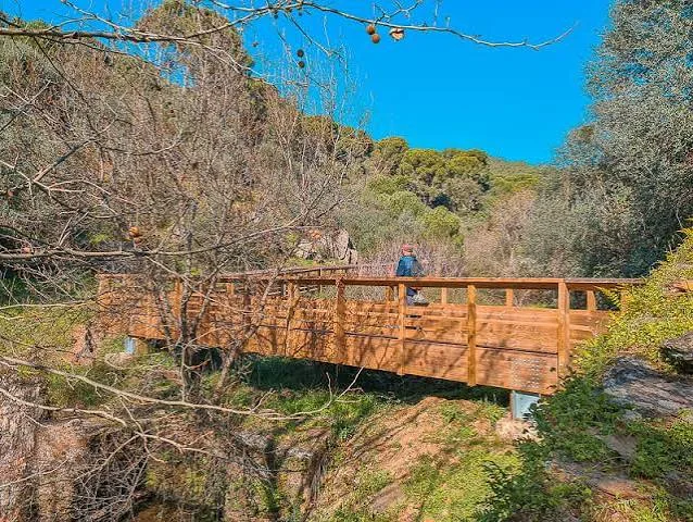 Wooden footbridge across a rocky valley on the Passadiços da Serra d'Ossa