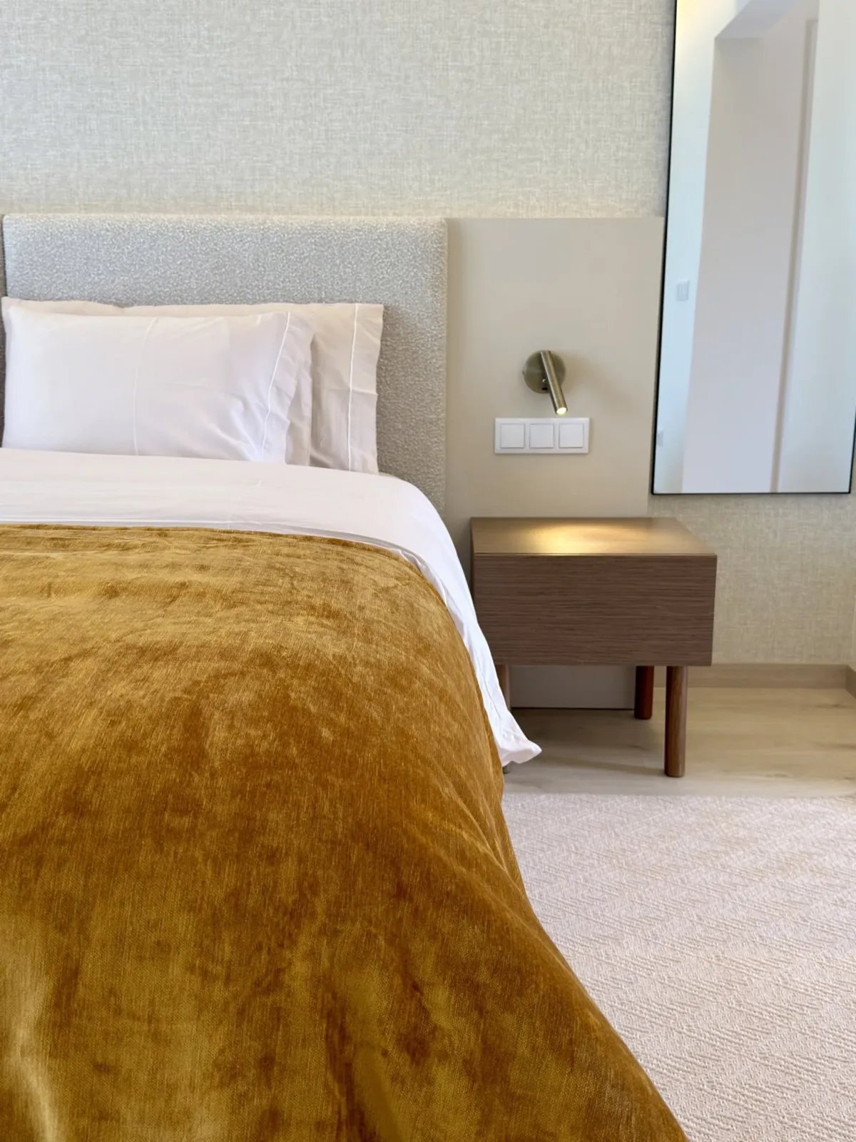 Cama de casal com uma manta de veludo mostarda