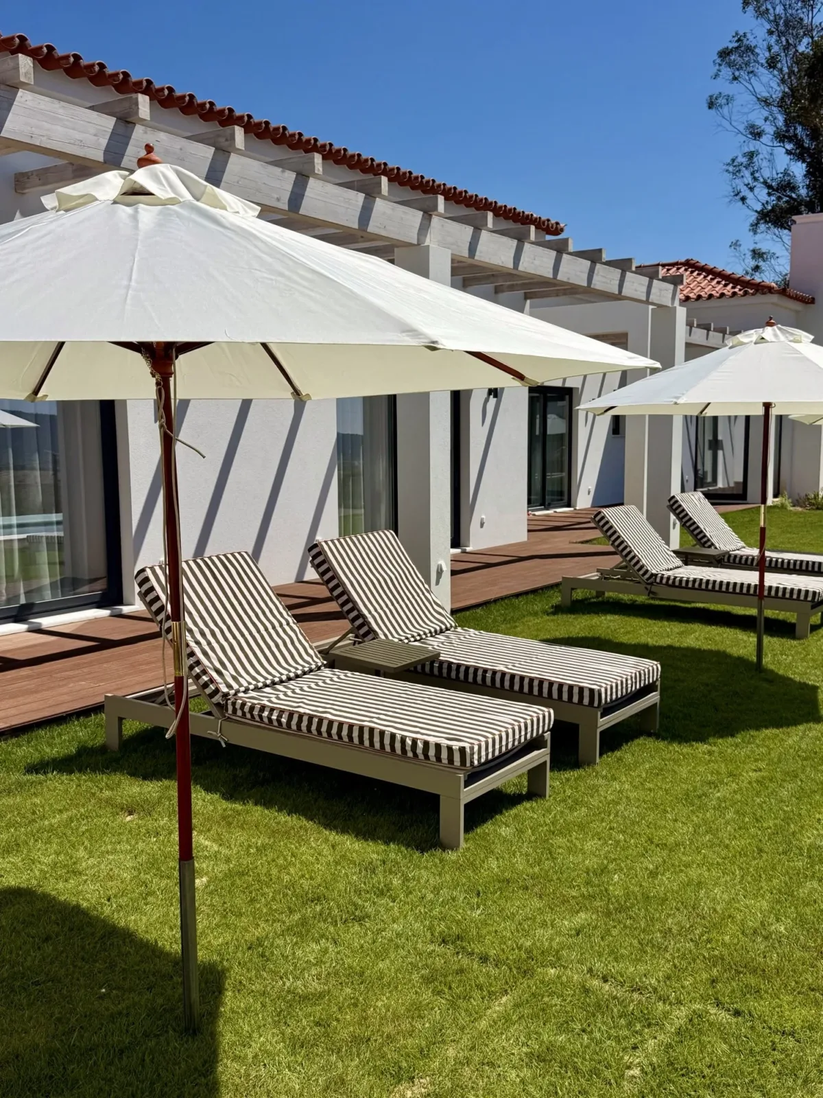 Striped loungers and parasols on the lawn