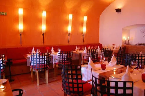 Orange-lit dining room at Cadeia Quinhentista with set tables