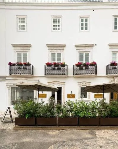 White facade with balconies and planters at Casa do Gadanha