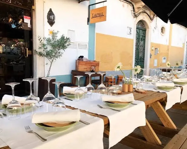 Outdoor table set with plates and glasses at Larau