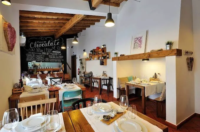 Dining room at Gadanha Mercearia & Restaurante with wooden tables and a chalkboard sign