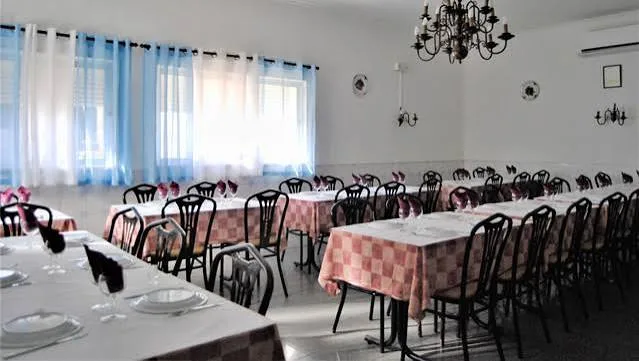 Dining room at O Formiguinha with checked tablecloths and curtains