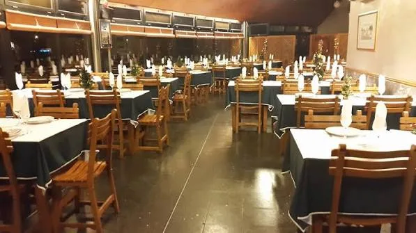 Dining room at Os Cucos with long tables laid with white napkins