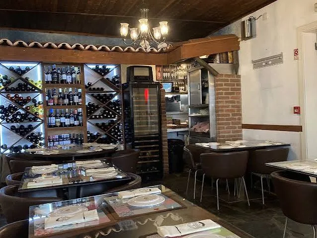 Dining room at Restauração with a wine rack and dark tables